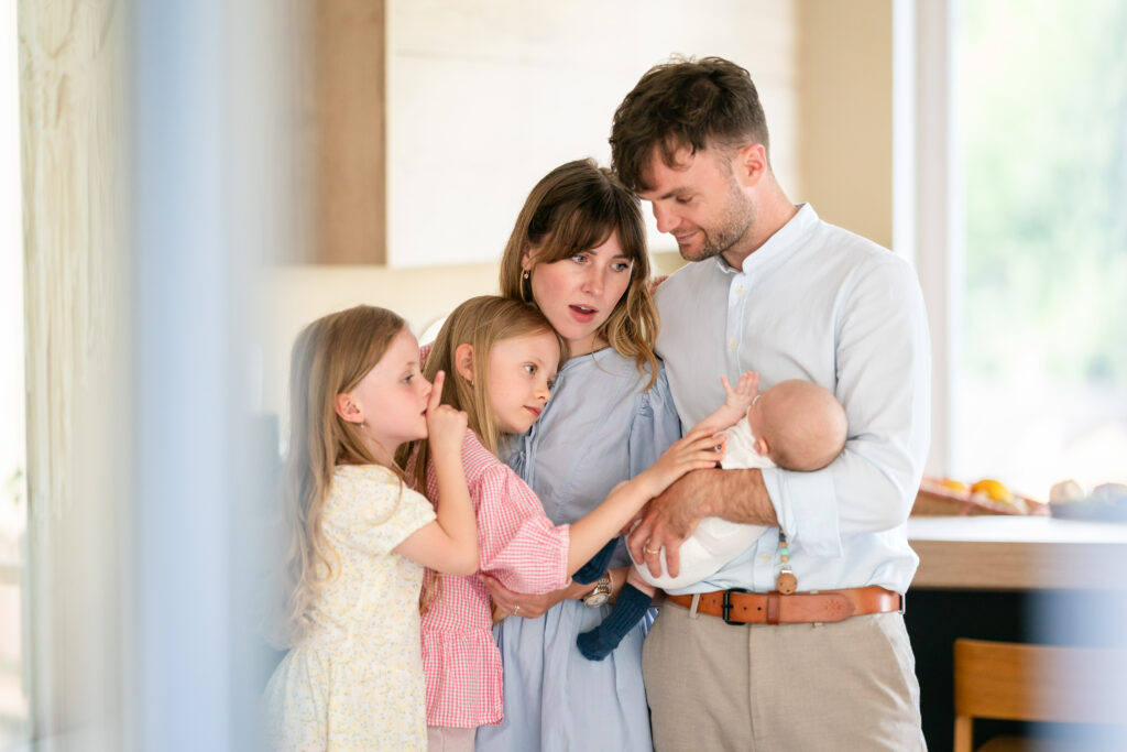 A happy family sitting together on a couch at home.
